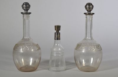 trois bouteilles en verre posées les unes à côté des autres sur une table