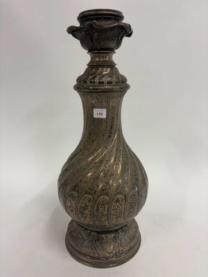 une photo d'un vase argenté posé sur une table blanche