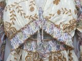 a white dress with a gold and blue pattern on it