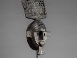 an image of a wooden mask on a metal stand