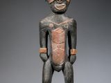 une statue en bois représentant un homme avec un bandage autour de la tête