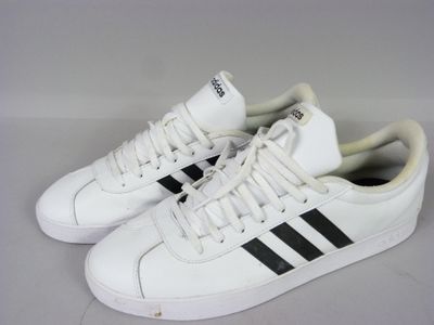white and black adidas sneakers on a white surface