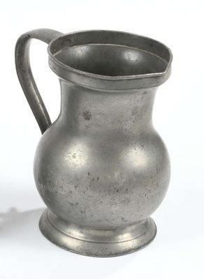 a silver pitcher sitting on a table next to a white background