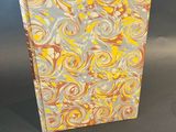 a yellow and grey notebook with a spiral design on it