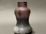 a vase that is sitting on a table with a gray background