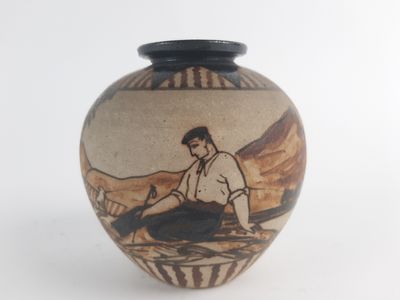 a vase with a picture of a man sitting on the ground