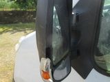 a white van with a black side mirror on it ' s side