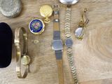 a lot of watches and other jewelry on a table