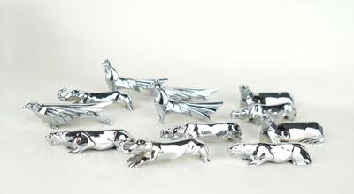 un ensemble de figurines d'animaux en argent posées sur un fond blanc