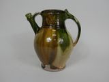 a brown and green vase on a white surface