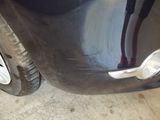 a close up of a car ' s front bumper and tire