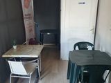 a table and chairs in a room with a clock on the wall