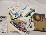 a lot of old cars and brochures on a bed
