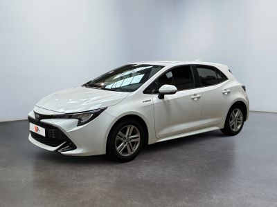 une Toyota Corolla blanche garée dans une grande pièce