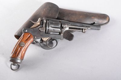 un vieux revolver avec une poignée en bois sur une surface blanche