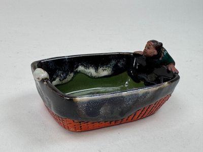une figurine représentant un homme dans un bateau sur l'eau