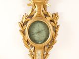a gold clock on the wall with a bird on it