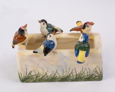 trois oiseaux perchés dans une jardinière