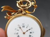 someone is holding a gold pocket watch with roman numerals on it