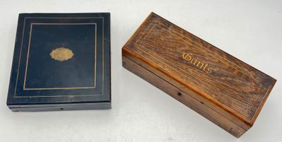an old wooden box with a black cover and a wooden box with a gold leaf on it