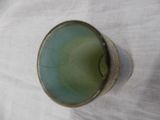 a green glass sitting on top of a white table