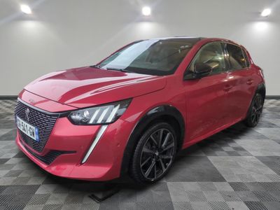une voiture rouge garée dans un garage au sol en damier