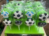 un assortiment de sucettes sur le thème du football dans une boîte verte
