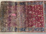 un vieux tapis orné d'un motif rose et bleu