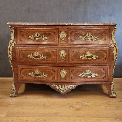 an antique chest of drawers with a marble top on a wooden floor