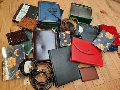 de nombreux modèles différents de sacs à main et de portefeuilles disposés sur une table