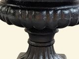 a black urn that is sitting on a pedestal