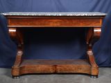 une vieille table en bois avec un plateau en marbre sur fond bleu