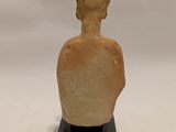 statue of a man with a hat on his head sitting on a black base