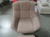a chair with a foot stool in the middle of the room