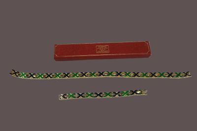 two bracelets and a red box on a gray surface