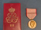 une image représentant un livre rouge orné d'une médaille