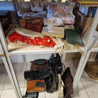une étagère sur laquelle sont posés de nombreux livres et sacs