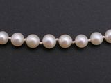 a strand of white pearls on a black surface