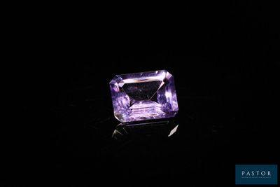 une pierre d'améthorate violette posée sur une surface noire