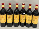 six bouteilles de vin rouge alignées sur une table