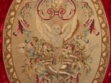 an embroidered picture of a bird on a red velvet background