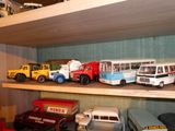 de nombreuses petites voitures et de nombreux petits camions sur une étagère dans une pièce