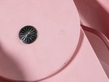 someone is holding a pink purse with a compass on it
