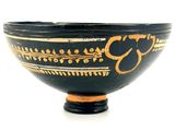 a black and gold bowl on a white surface