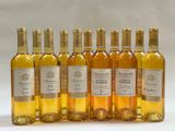 six bottles of wine are lined up in a row on a white surface