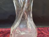 un vase en verre posé sur un tissu rouge