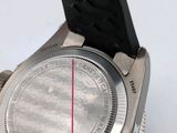 a close up of a watch with a red line on the face
