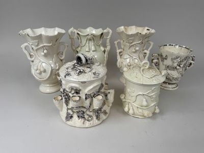 four white vases sitting next to each other on a table
