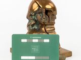 a bronze statue of a man holding a credit card