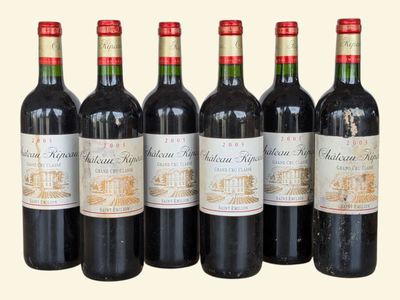 six bottles of red wine lined up in a row on a table